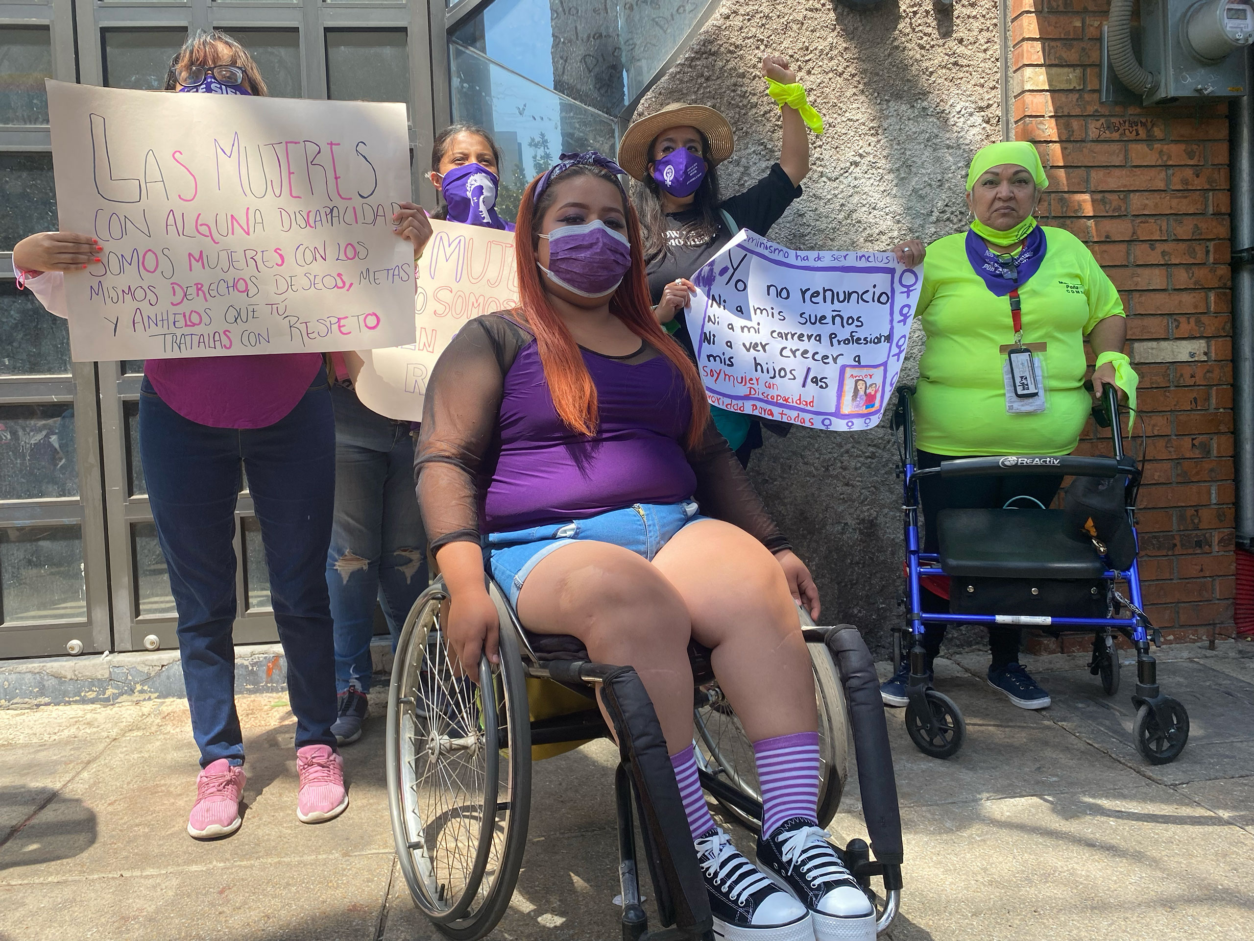 Fotografía. Mujeres con discapacidad se preparan para comenzar la marcha del #8M de 2022 en la Ciudad de México. Descripción: Cinco mujeres con diferentes discapacidades están por comenzar el recorrido de la marcha del 8M. Crédito: Uriel Blanco